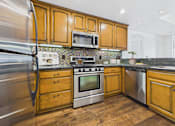 Thumbnail 1 of 88 - A kitchen with wooden cabinets and stainless steel appliances.