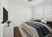 Thumbnail 9 of 88 - A bedroom with a bed, a television, and a vase of flowers.
