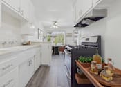 Thumbnail 12 of 30 - A modern kitchen with white cabinets and a wooden island.