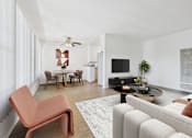 Thumbnail 5 of 30 - A living room with a white couch and a red chair.