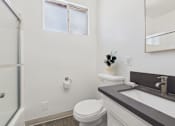 Thumbnail 10 of 30 - A white toilet sits next to a sink in a bathroom.