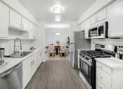 Thumbnail 1 of 17 - a kitchen with stainless steel appliances and white cabinets