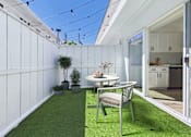 Thumbnail 7 of 12 - A patio with a table and chairs is shown.