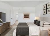 Thumbnail 8 of 12 - A bedroom with a large bed and a flat screen TV.