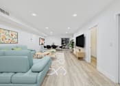 Thumbnail 11 of 39 - A living room with a light blue couch and a television.