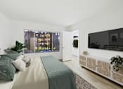 Thumbnail 16 of 39 - A bedroom with a large bed and a television on the wall.