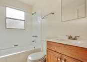 Thumbnail 6 of 21 - A white bathroom with a toilet, sink, and bathtub.