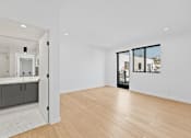 Thumbnail 81 of 119 - A spacious room with wooden flooring and a view of the city through the windows.