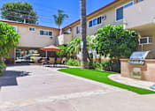 Thumbnail 75 of 78 - A sunny day at a residential area with apartment buildings and a green lawn.
