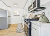 Thumbnail 2 of 78 - A kitchen with a stove, refrigerator, and microwave.