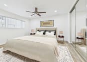Thumbnail 9 of 78 - A bedroom with a large bed and a ceiling fan.