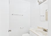 Thumbnail 27 of 43 - A white bathroom with a toilet, sink and towel bar.