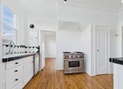 Thumbnail 11 of 23 - A kitchen with a stove and oven in the middle of the room.