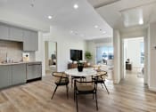 Thumbnail 2 of 90 - A modern kitchen with a dining table and chairs.