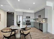 Thumbnail 1 of 90 - A modern kitchen with a dining table and chairs.