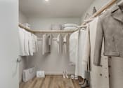 Thumbnail 7 of 90 - A row of clothes hanging on a rack in a room.