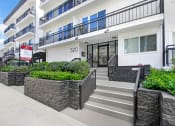 Thumbnail 25 of 26 - the front entrance of an apartment building with stairs and a sidewalk