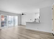 Thumbnail 19 of 26 - an empty living room with a kitchen and a balcony