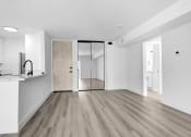 Thumbnail 20 of 26 - an empty living room with a kitchen and a sliding glass door