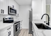 Thumbnail 17 of 26 - a kitchen with white cabinets and stainless steel appliances
