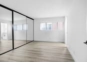 Thumbnail 22 of 26 - an empty room with white walls and a glass door