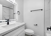 Thumbnail 23 of 26 - a bathroom with a sink and a mirror and a toilet