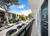 Thumbnail 21 of 26 - a balcony with a view of a city street and cars