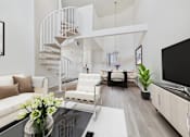 Thumbnail 6 of 108 - A white living room with a spiral staircase.