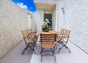 Thumbnail 7 of 108 - A table with chairs is set up on a patio.