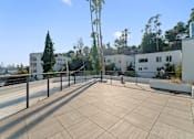 Thumbnail 74 of 119 - A rooftop with a metal railing and a tiled floor.