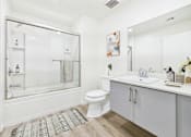 Thumbnail 10 of 61 - A white bathroom with a glass shower door and a white toilet.