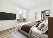 Thumbnail 8 of 61 - A bedroom with a large bed and a flat screen TV mounted on the wall.