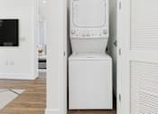 Thumbnail 9 of 45 - A white washing machine in a small room.