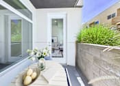 Thumbnail 6 of 45 - A white door is open to a patio with a table and chairs.