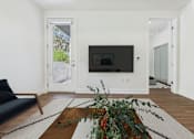 Thumbnail 4 of 45 - A living room with a black couch and a television.
