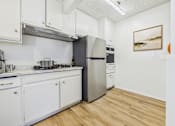 Thumbnail 2 of 36 - A kitchen with a stove, oven, and refrigerator.