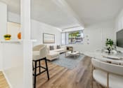 Thumbnail 4 of 36 - A living room with a white couch and a wooden floor.