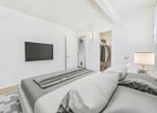 Thumbnail 7 of 36 - A bedroom with a large bed and a flat screen TV mounted on the wall.