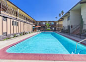 Thumbnail 35 of 36 - A swimming pool in a residential area with buildings on either side.