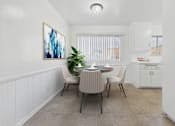 Thumbnail 2 of 13 - A dining room with a table set for two and a painting on the wall.