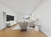 Thumbnail 4 of 13 - A modern living room with a grey chair and a white side table.