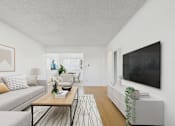 Thumbnail 3 of 13 - A living room with a grey couch, a coffee table, and a flat screen TV mounted on the wall.