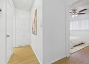 Thumbnail 7 of 13 - A room with a ceiling fan and a bed in the other room.