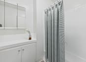Thumbnail 8 of 16 - A white bathroom with a glass shower door.