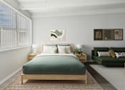 Thumbnail 5 of 16 - A bedroom with a bed, nightstands, and a couch.