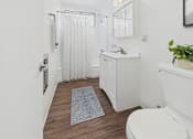 Thumbnail 30 of 37 - A white bathroom with a toilet, sink, and shower.