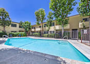 Thumbnail 54 of 55 - A swimming pool in front of a building with trees.