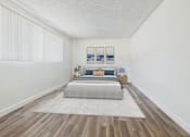 Thumbnail 9 of 55 - A bedroom with a bed, pillows, a nightstand, a rug, and pictures on the wall.
