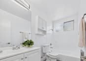 Thumbnail 10 of 37 - A white bathroom with a toilet, sink, and mirror.