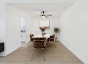 Thumbnail 3 of 37 - A dining room with a white table and brown chairs.